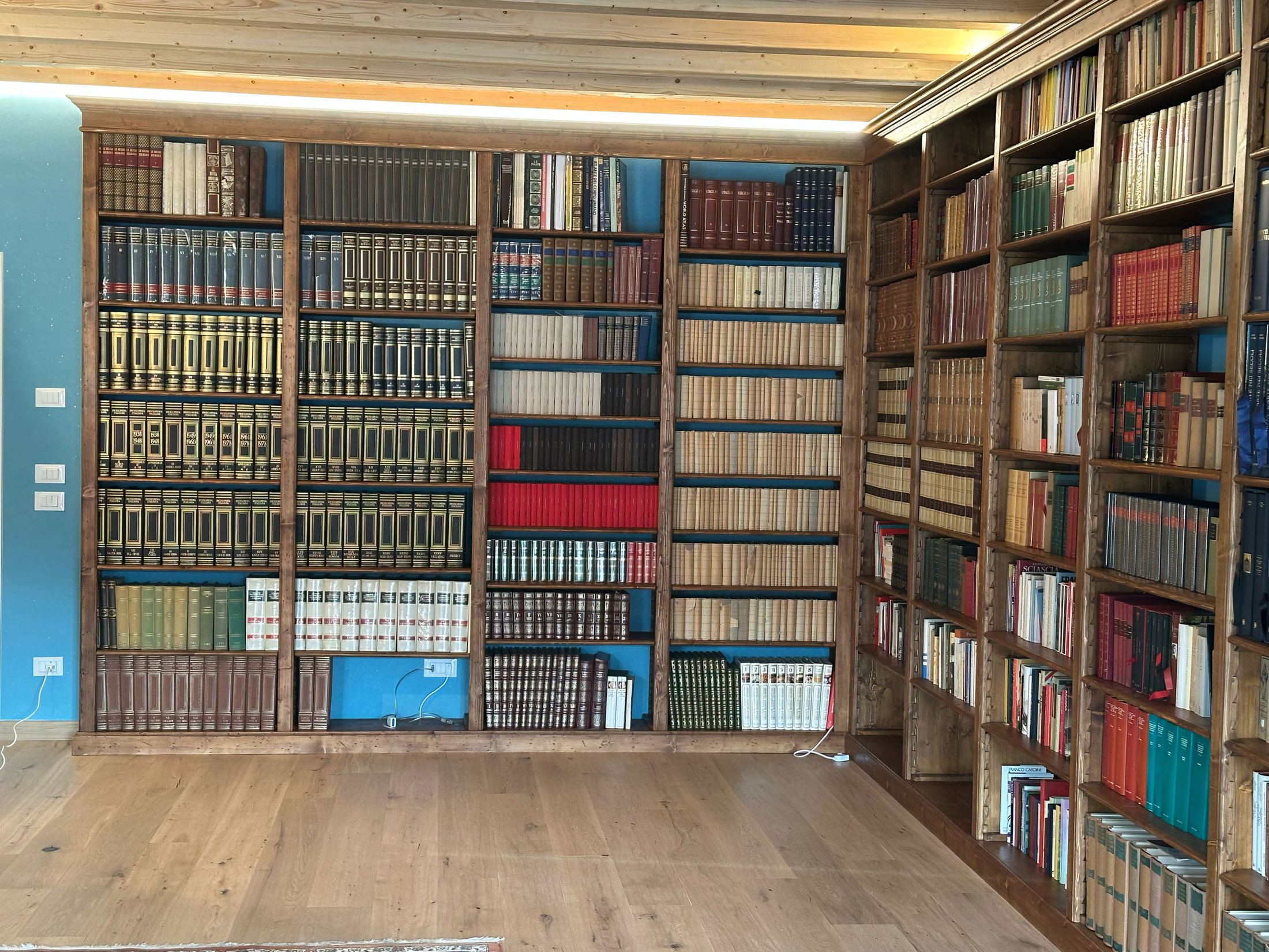 Libreria su misura a tutta parete con travi a vista, living artigianale Mobili Granci